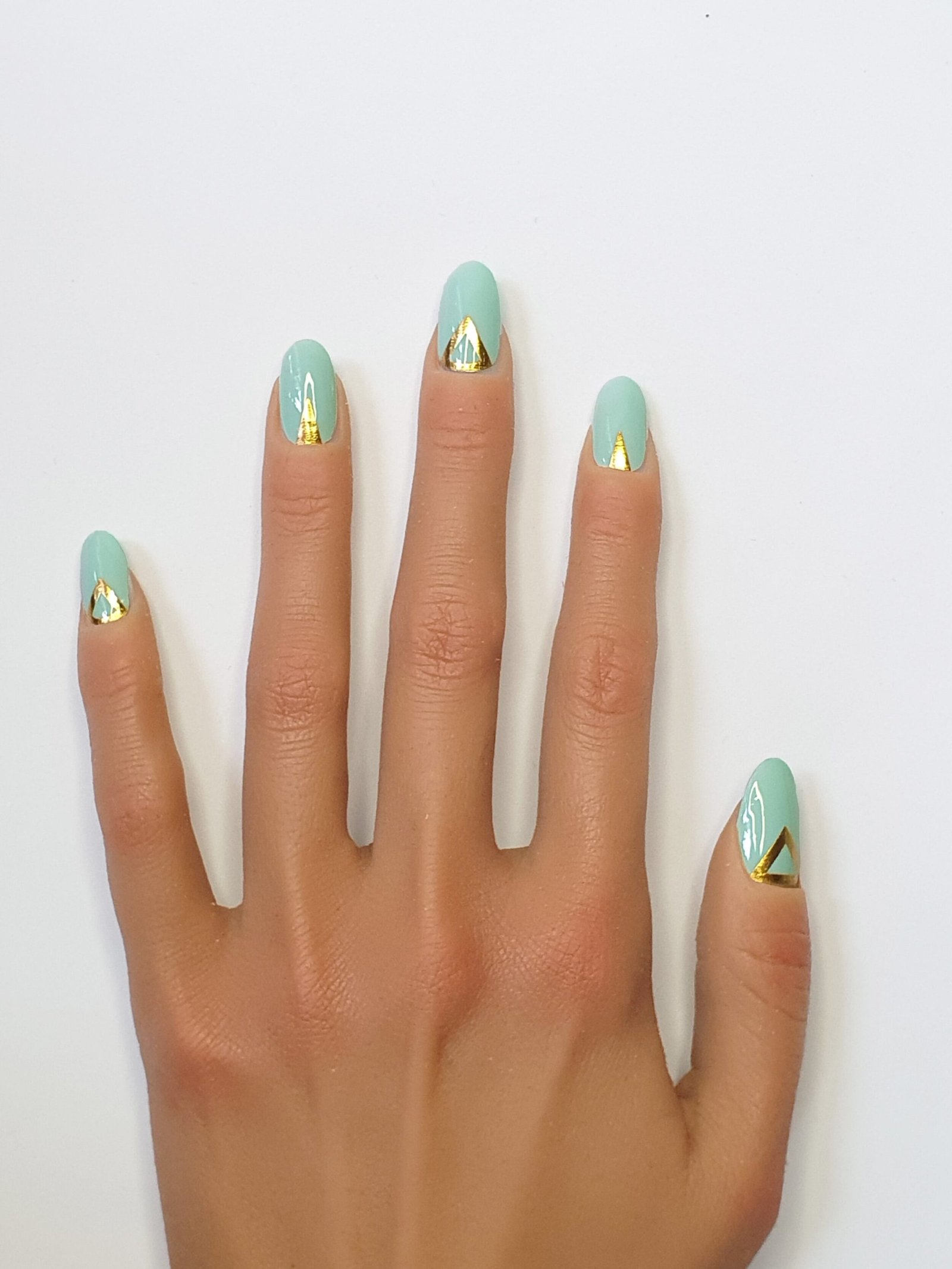 Ongles turquoise et triangles géométriques dorés