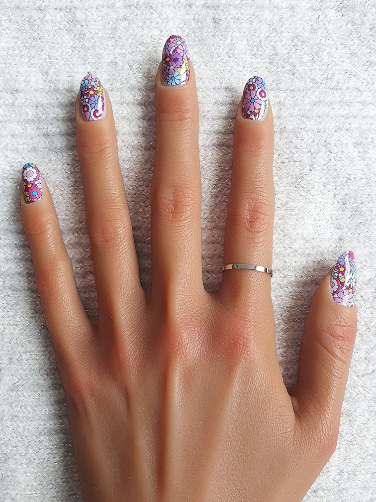 Ongles avec stickers nail art floraux colorés et vibrants.