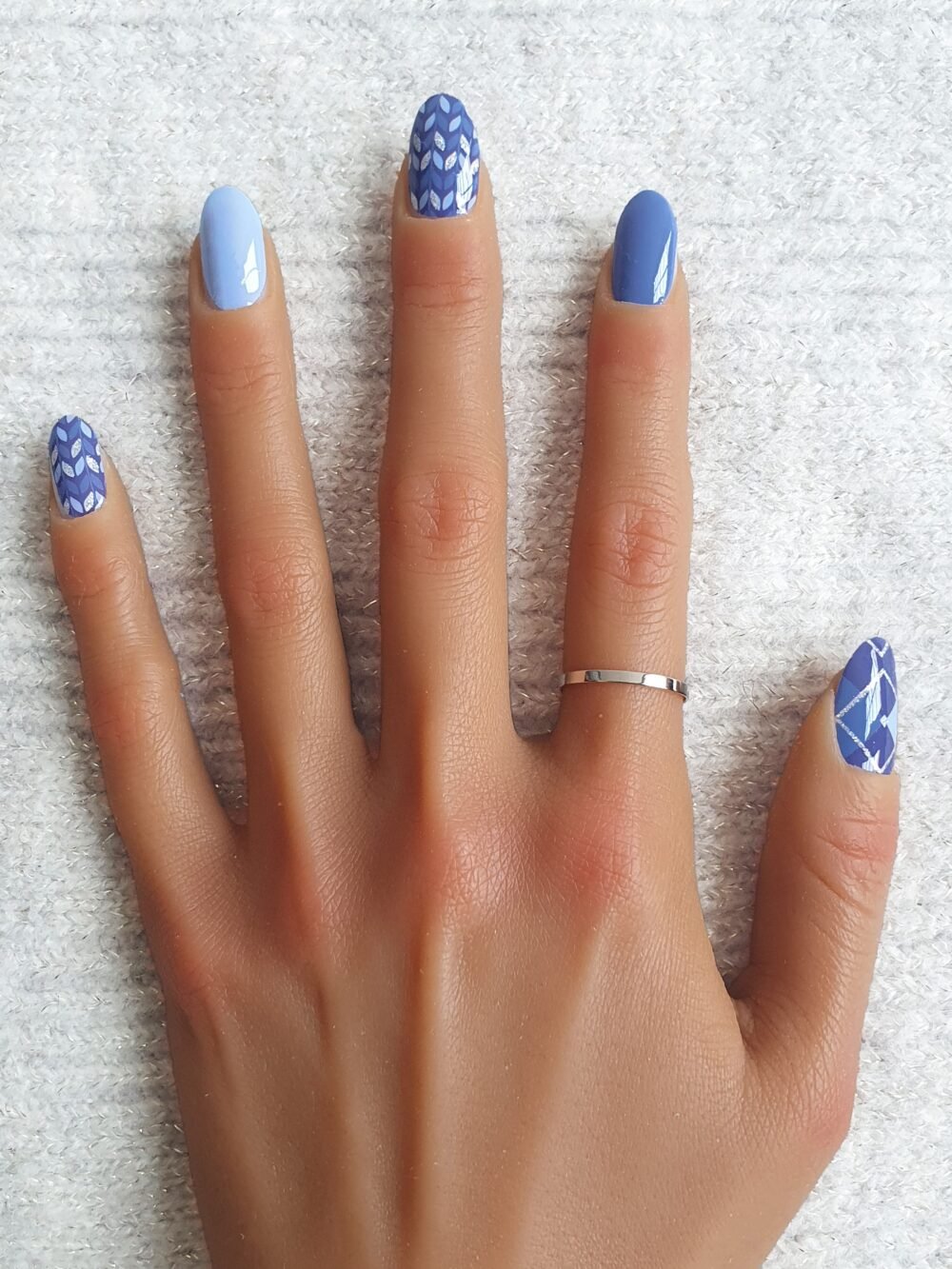 Manucure moderne avec des nail patches bleus et argentés.
