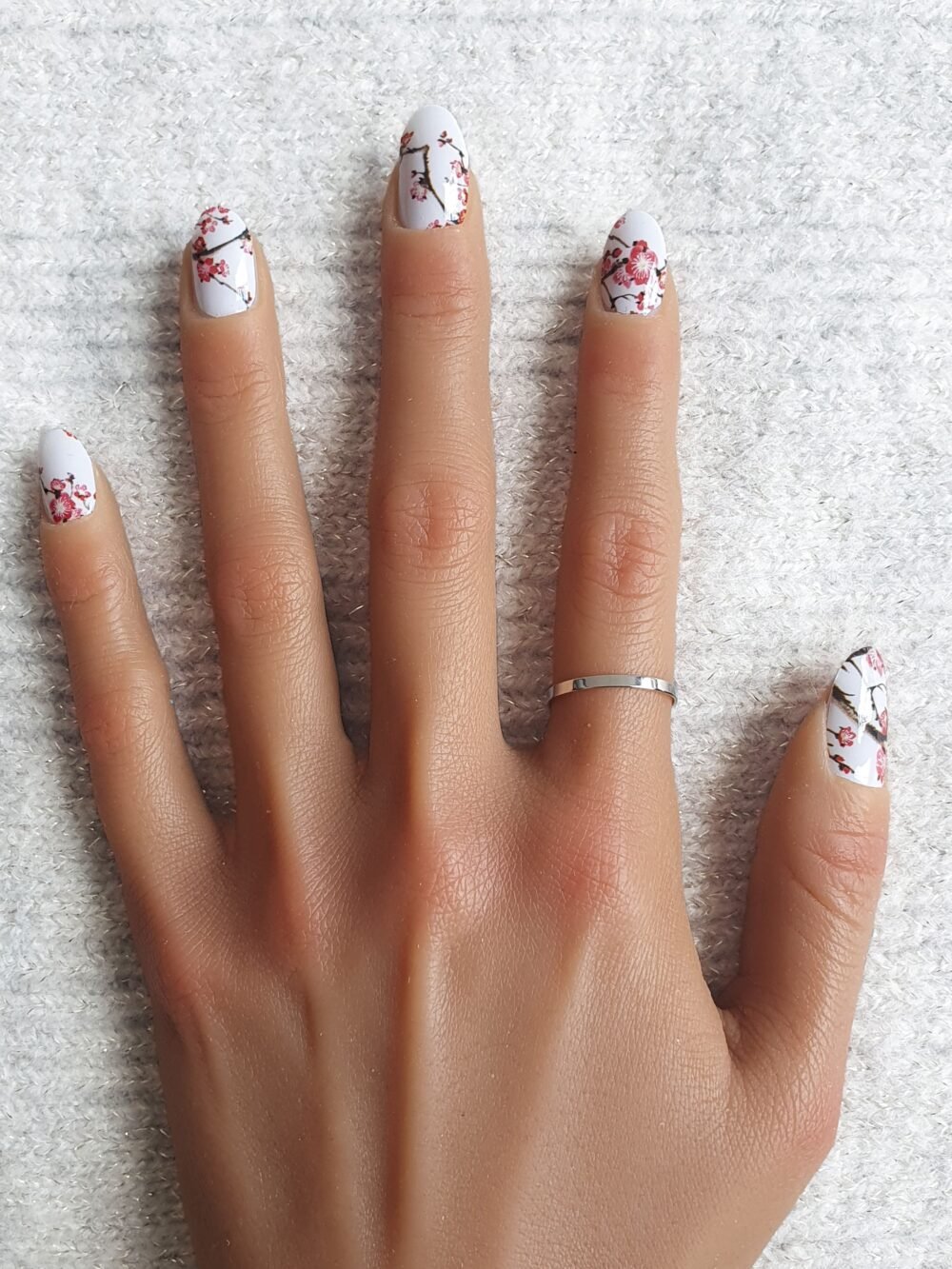 Nail art Sakura : stickers au fond blanc et fleurs de cerisiers.