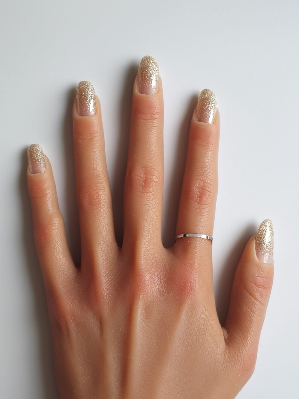 Ongles pailletés dorés pour Noël : le modèle Champagne, pour briller lors des fêtes.