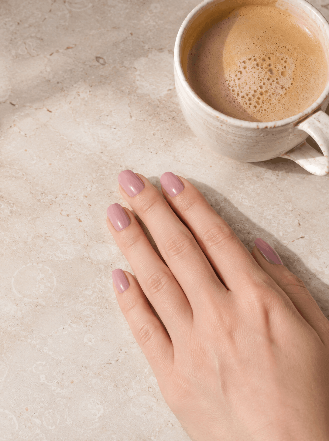 Vernis rose poudré à côté d'un café
