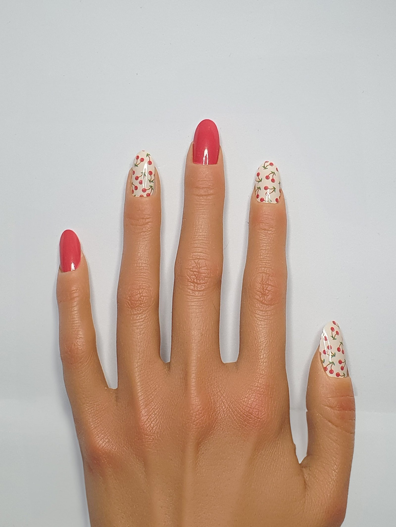 Une mains aux ongles cerise