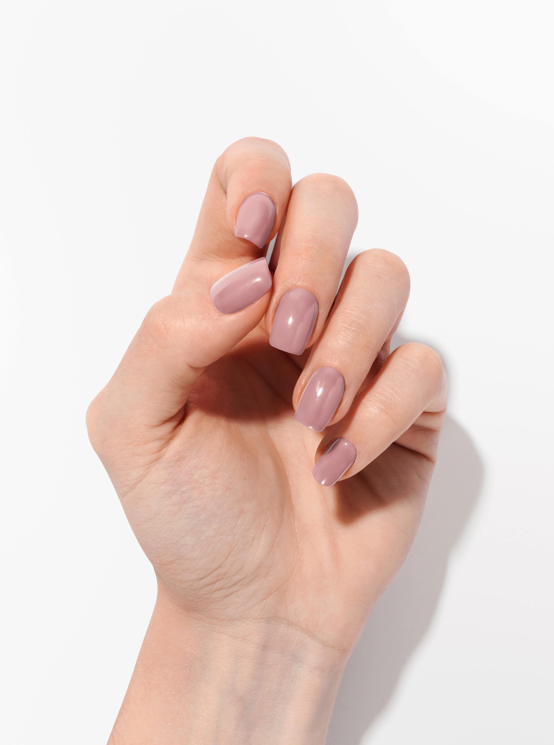 Un vernis rose poudré sur ongles longs en forme arrondie